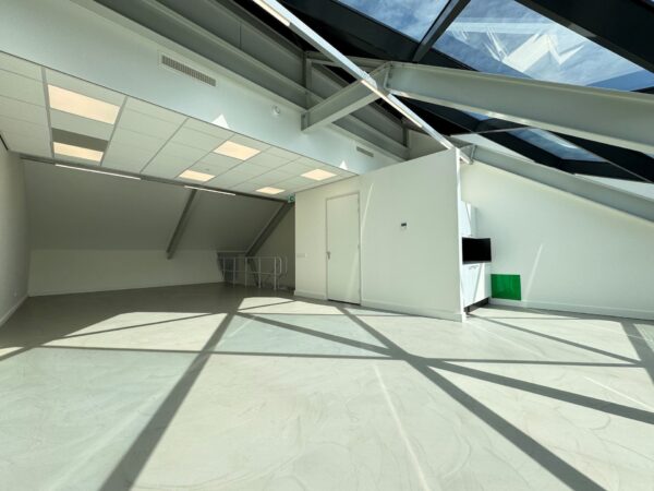 Licht en modern kantoor op de bovenverdieping van Mart Stamhof met grote dakramen en strakke afwerking.